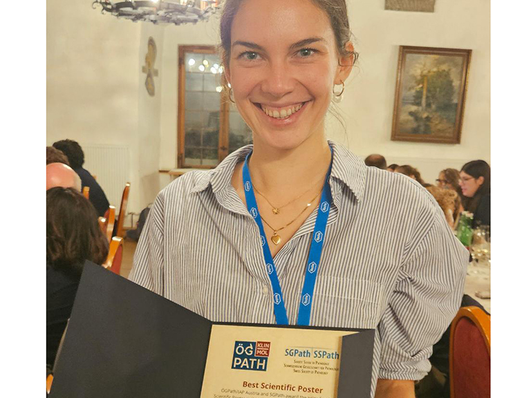 Picture by Ana Leni Frei with diploma for best poster